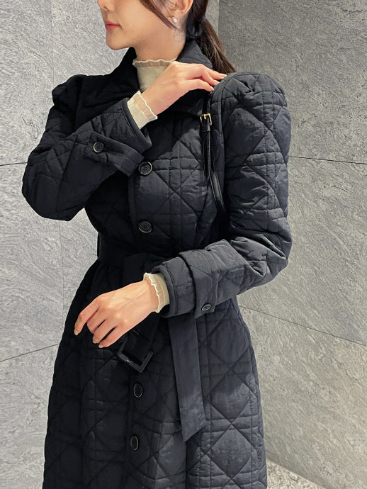 ブラックのキルティングロングコートの上半身アップ、シャツカラーとフロントボタン、ベルトバックルや袖口ディテールが分かる大人可愛いオフィスカジュアル冬アウター。
