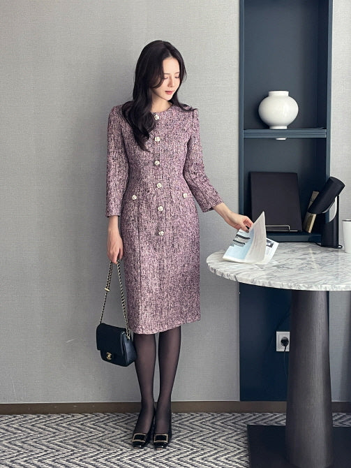 パープルツイードのミディ丈ワンピースを着た女性がホテルの部屋で立っているシーン。上品でクラシックなシルエットが魅力の大人フェミニンスタイル。