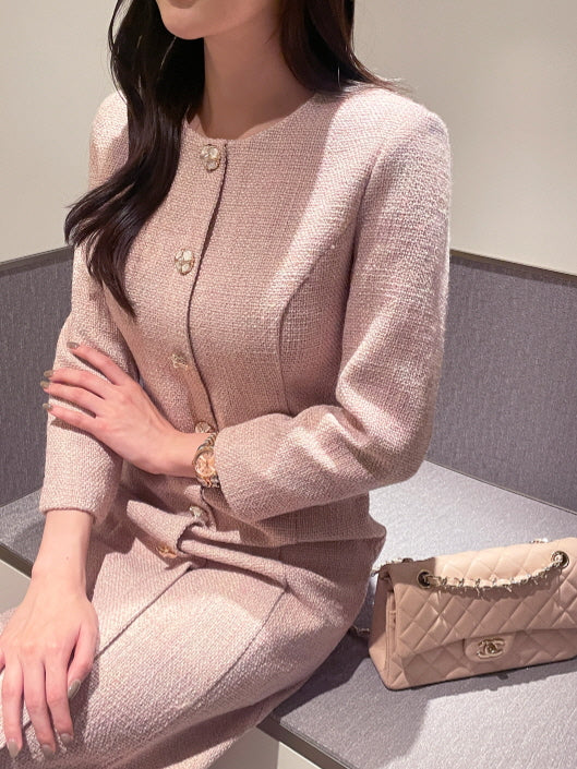ピンクツイードの上品なワンピースを着た女性の上半身コーデ。ゴールドとパールのボタンが輝く、大人フェミニンでエレガントなクラシックスタイル。
