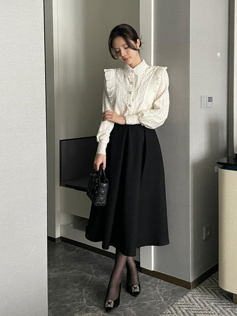 パールボタン付きレースブラウスと黒のロングフレアスカートを合わせた、オフィスカジュアルにも使えるエレガントなレディースコーデの全身写真